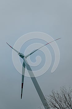 Low angle shot of a wind turbine against the cloudy sky