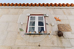 Low-angle shot of a window with a wooden frame decorated with different objects in Moncorvo