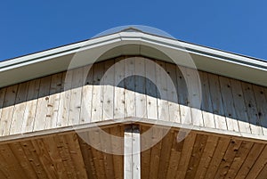 Low angle shot of a wooden roof overhangs against a blue sky photo