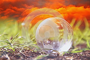 low angle small crystal globe in the grass. travel and global issues concept.