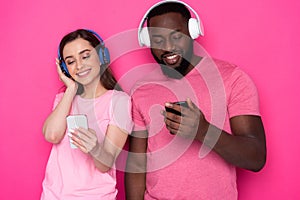 Close up of happy interracial couple wearing modern headphones in studio