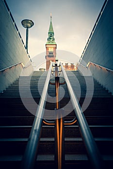 Low angle vertical shot of underground exit on Copenhagen City Hall tower background
