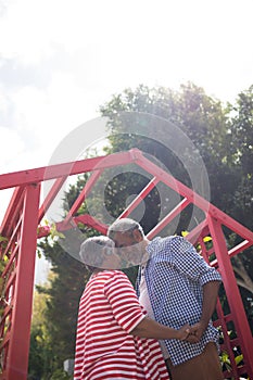 Low angle view of affectionate senior couple against sky