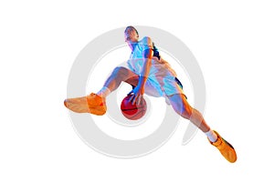Low angle view. Basketball player performing dynamic dribbling in jump against white studio background in neon light.
