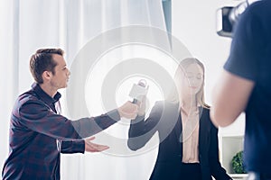 Low angle view of beautiful businesswoman in suit rejecting giving interview to journalist