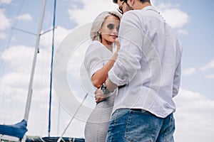 low angle view of beautiful stylish young couple in sunglasses hugging