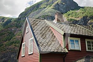 low angle view of beautiful wooden house in Flam village and majestic mountains Aurlandsfjord