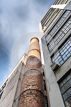 Low angle view of brick chimney of old industrial building