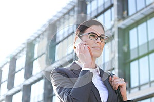 Low angle view of businesswoman using cell phone outside office building