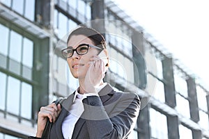 Low angle view of businesswoman using cell phone outside office building