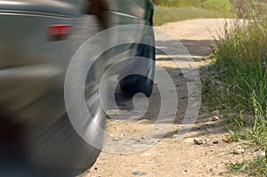 Low Angle View Of A Car Driving On A Country Road On A Sunny Summer Day. Motion Blur Effect.