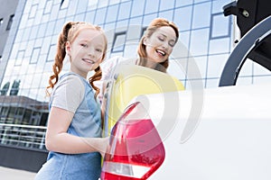 low angle view of cheerful family putting baggage into car