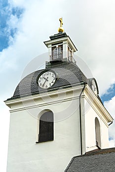 Low angle view of a church tower with bell cote and a golden cross photo