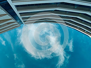 Low angle view of a cloudy blue sky with a Wall of a tall building