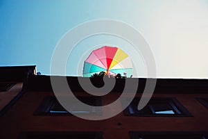 low angle view of colorful umbrella on building against clear sky