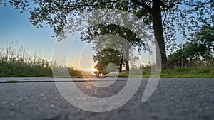 Low angle view of a country road under a dramatic colorful sunset sky. Beautiful Evening Sky Above Rural Landscape With