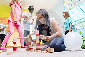 Cute girl building a structure in balance during playtime at the kindergarten