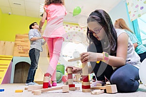 Cute girl building a structure in balance during playtime at the kindergarten