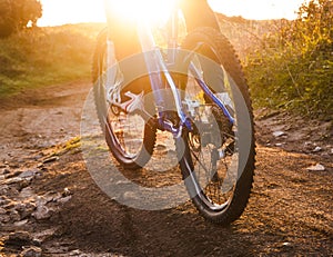 Low angle view of cyclist riding mountain bike trail at sunrise
