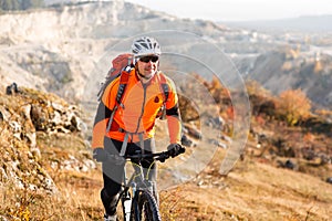 Low angle view of cyclist standing with mountain bike on trail at sunset