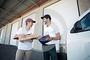 Low angle view of delivery people are looking each other and laughing