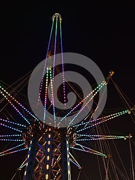 Low angle view of drop tower with illuminated structure at night in park Wurstelprater near Wiener Prater in city Vienna, Austria.