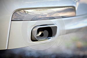 Low angle view of the exhaust pipe of a car with selective focus on tailpipe