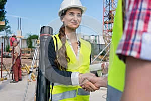 Architect and engineer or supervisor shaking hands on the construction site