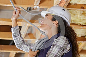 low angle view female electrician installing cable trunking