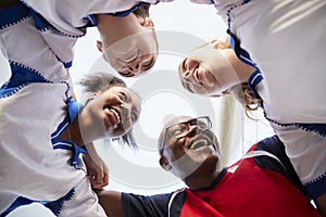 Low Angle View Of Female High School Soccer Players And Coach Having Team Talk