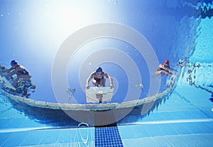 Low angle view of female swimmers ready to dive in pool from starting position