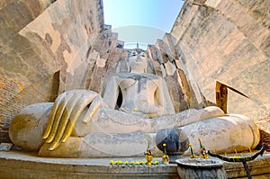 Low angle view of a giant ancient Buddha statue in Temple Wat Si Chum in Sukhothai Historical Park, Thailand