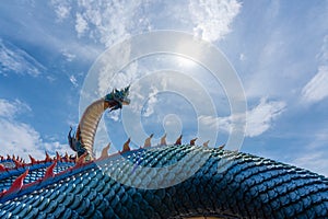 Low angle view Giant Naka Buddha on blue sky clouds  at Mukdahan Province, Thailand.