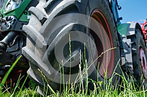 Low angle view through grass to tractor wheel. Agricultural landscape