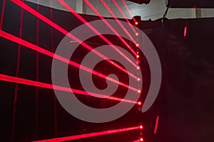 Low-angle view of a grid of vibrant red neon lights diffusing through a translucent screen, set against a dark background.