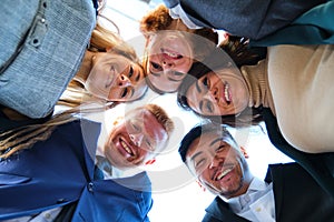 Low angle view of a group of international happy businesspeople in circle.
