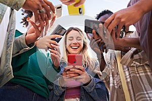 Low angle view of a group of young teenagers using cell phones. Concept of technology, connection.