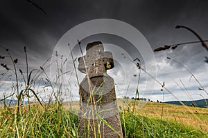 Low angle view of a hand carved old stone cross , dramatic stormclouds