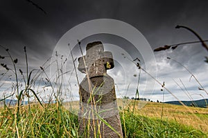 Low angle view of a hand carved old stone cross , dramatic stormclouds photo