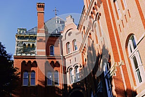 Low-angle view of historical buildings with arch-shaped window frames and ornated roofs