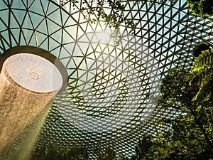 Low angle view of the HSBC rain vortex indoor waterfall at Jewel mall, Changi airport, Singapore. The waterfall is surrounded by a