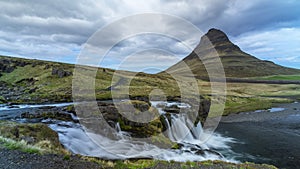 Low angle view of the Kirkjufellsfoss water fall near Grundarfjordur town in Iceland