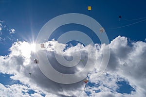 Low angle view of kites flying in cloudy sky