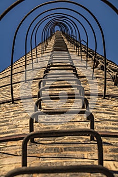 Low-angle view of the ladder of an old factory`s chimney