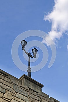 A low angle view of a lamp post on a stone bridge.