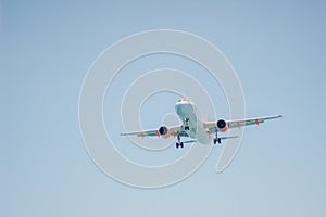 Low angle view of landing aircraft on blue sky