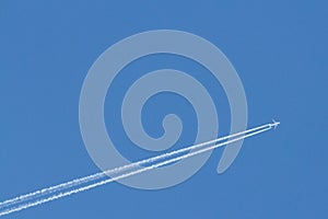 Low angle view of a long haul jet plane leaving a trail of smoke and steam