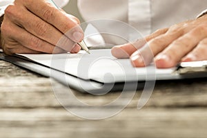 Low angle view of male hand signing contract or subscription for