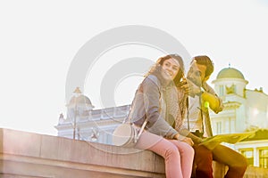 Low angle view of man holding map while sitting and talking to his girlfriend