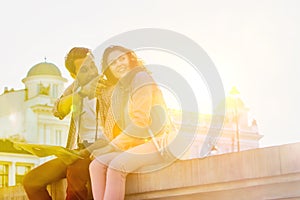 Low angle view of man holding map while sitting and talking to his girlfriend